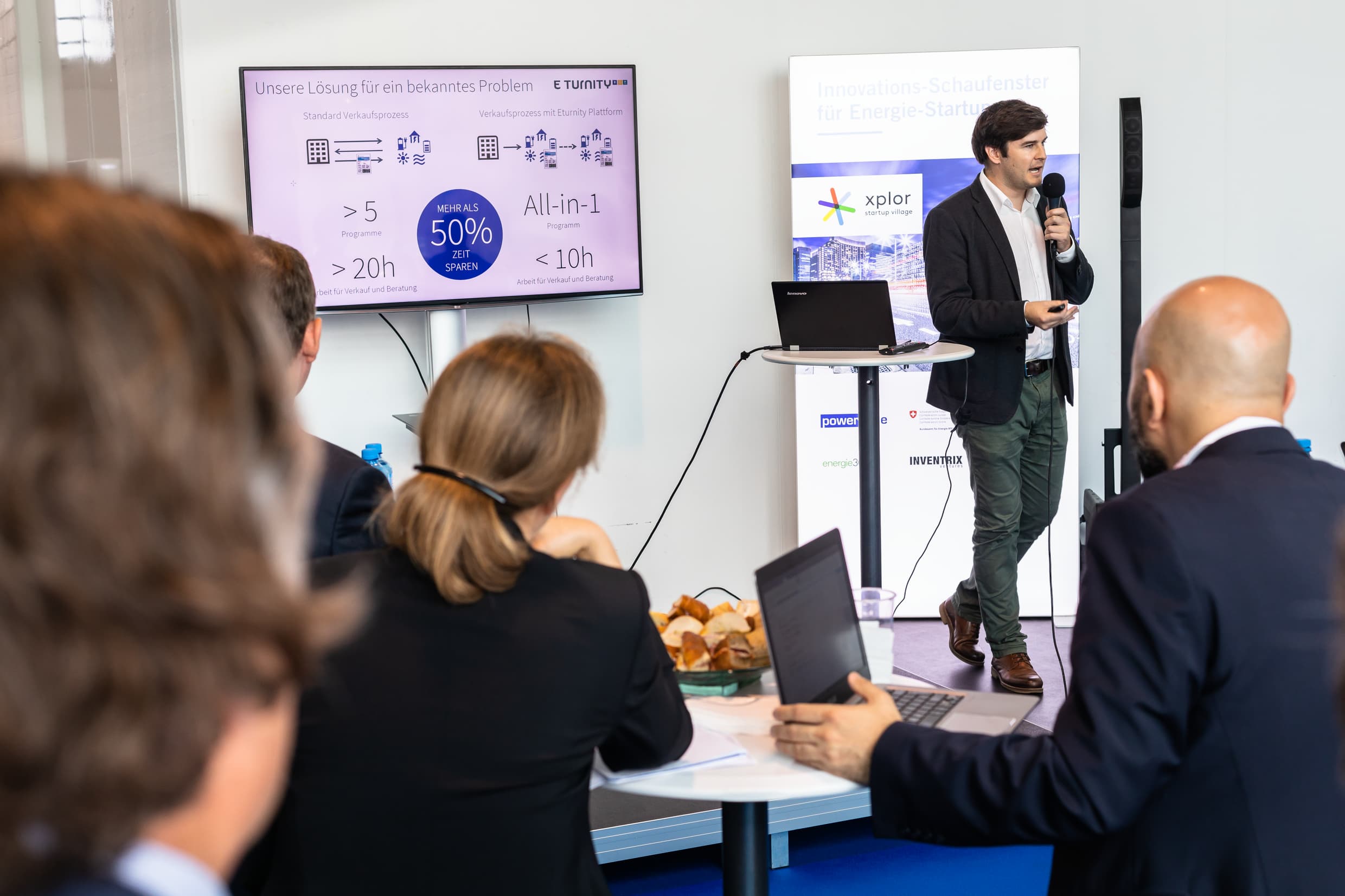 A presenter speaks into a microphone at xplor startup village.